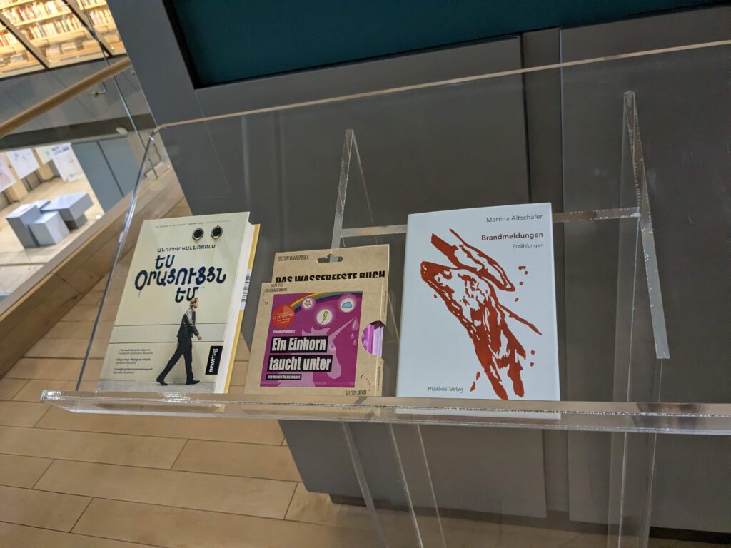 Neues Lesefutter für Rigas Nationalbibliothek: "Ein Einhorn taucht unter" (Edition Wannenbuch, Mitte) und "Brandmeldungen" (Mirabilis Verlag, re.)