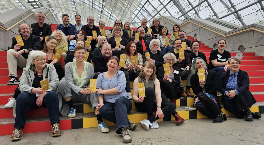 Verlegerinnen und Verleger aus dem Schöne-Bücher-Netzwerk beim Fototermin in der Glashalle der Leipziger Messe.